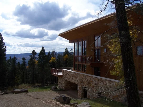 A mountain home with cream and brown Vista Grande Travertine masonry along its lower exterior wall.