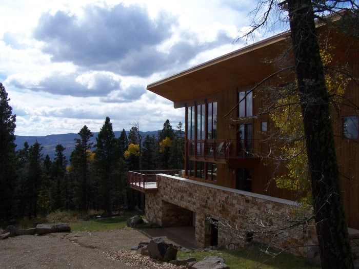A mountain home with cream and brown Vista Grande Travertine masonry along its lower exterior wall.