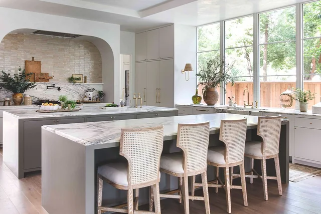 A light-filled kitchen with an Alabama Rose marble island and backsplash.